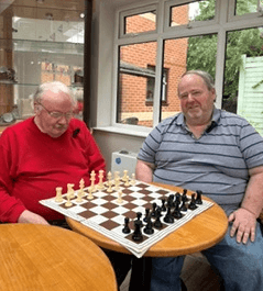 Two friends sitting beside their chess board at Roseleigh Care Home