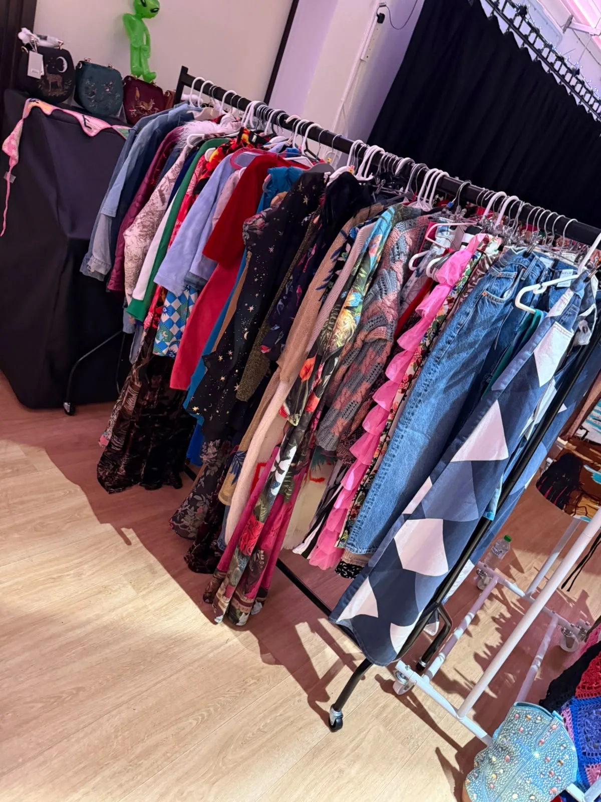Colourful vintage clothing arranged on a market rail